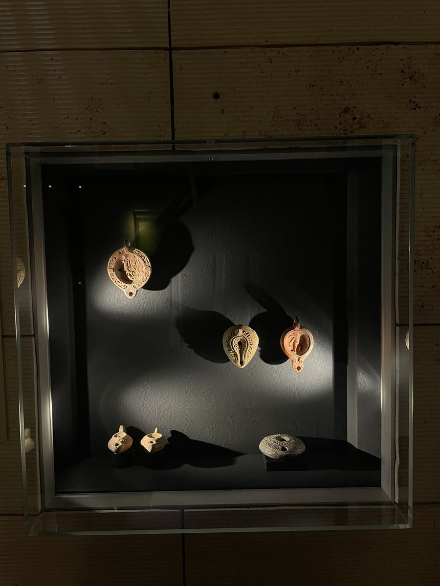 Pişmiş Toprak Kandiller
Roma Dönemi, MS 1-4. Yüzyıl, Anadolu
Kandil:  
-Ben, neşelendiren bardakların uzattığı geceleri severim: Sen ise su içip asık suratınla masadan kaçarsın. Sen karanlığı seversin: Ben ise şahitlik için bir kandil ile eğlenmeyi tercih ederim… <a href="/Comdjournal/">Bilkent Post Ankara</a>