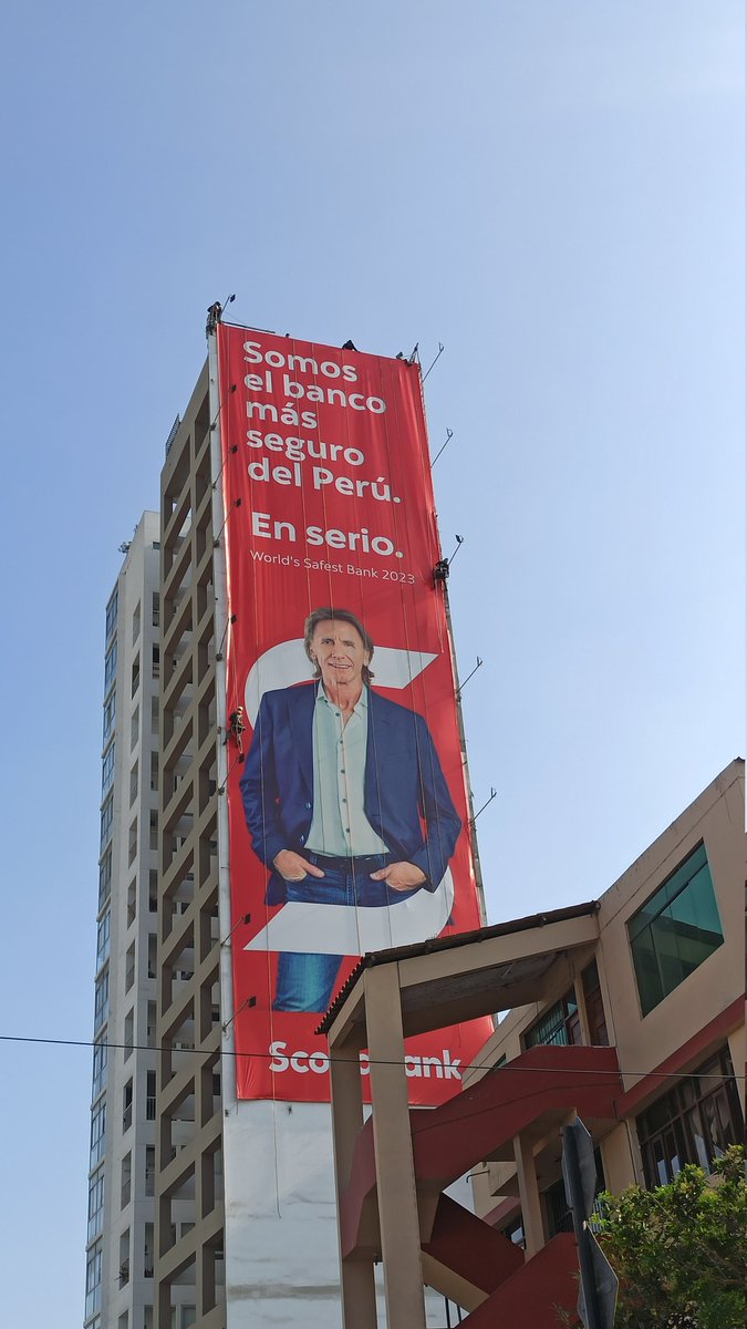 Trabajadores retirando el anuncio de Scotiabank con Ricardo Gareca