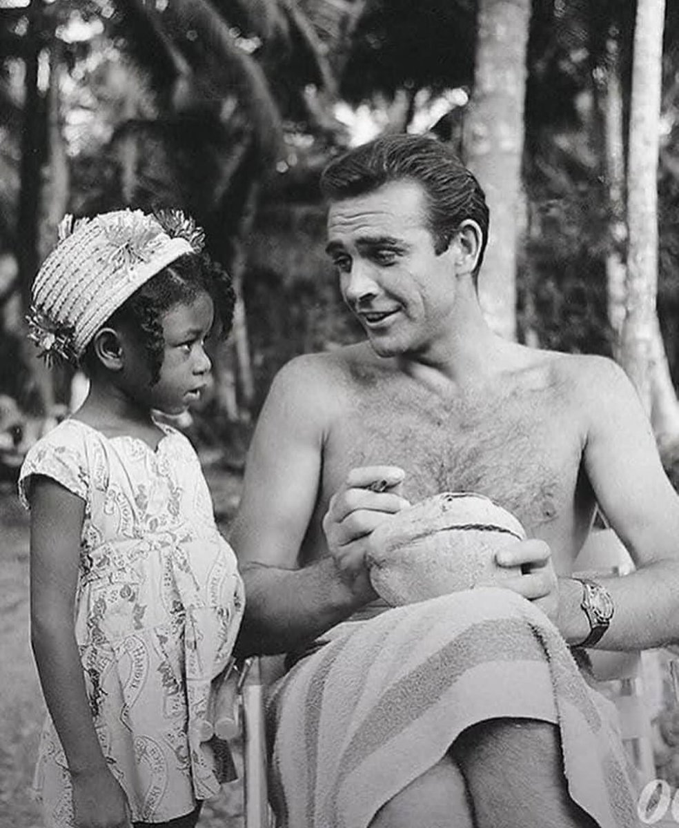Sean Connery signing a coconut for a little Jamaican fan on the set of Dr. No, 1962.