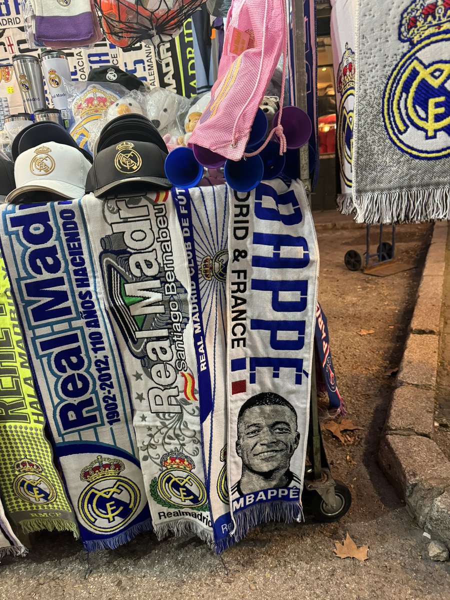 ActuFoot_'s tweet photo. On peut déjà se procurer l’écharpe 🧣 de Kylian Mbappé devant le Santiago Bernabeu. 🤍😅 https://t.co/QzsbcmO3jZ