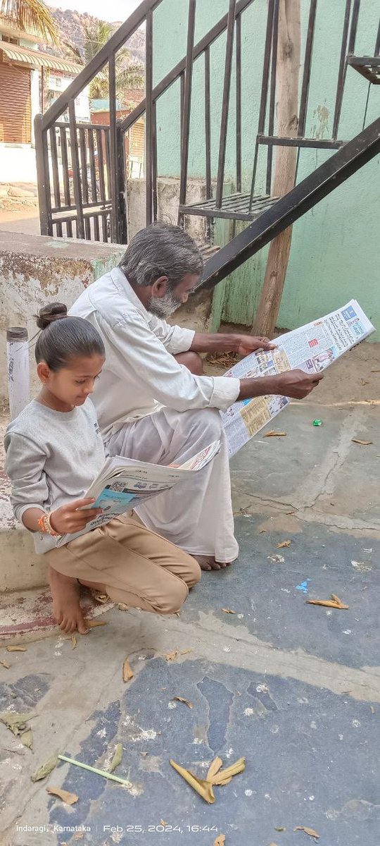 At the doorstep of the rural library, two different generations read the newspaper. #librariesforall