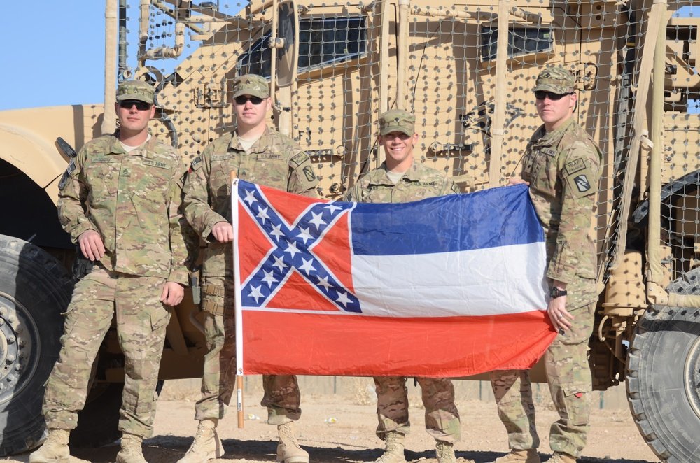 Staff Sgt. Lance Goode, Sgt. Brent Crutchfield, Spc. Joseph Sears and Spc. Justin Bridges (left-right) pose with the Mississippi state flag. They are members of the Mississippi Army National Guard serving with the Zabul Agribusiness Development Team in Zabul, Afghanistan.