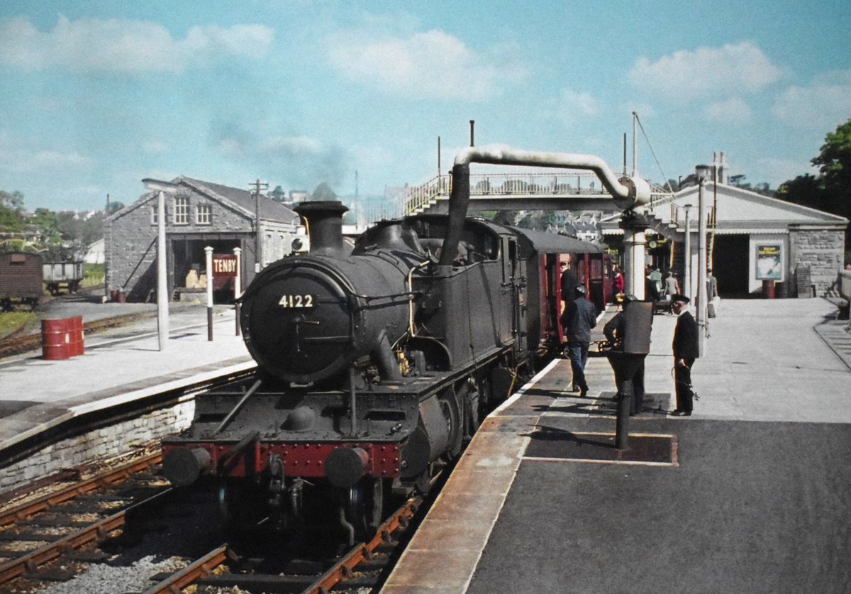 Prairie Tank 4122 has just arrived at #Tenby station with the 9.50am Whitland to #Pembroke Dock train. The scene looks busy with parcels being unloaded, & loco taking water.
Date: 2nd June 1962
📷 Photo by Michael Allen.
#steamlocomotive #1960s #SouthWales