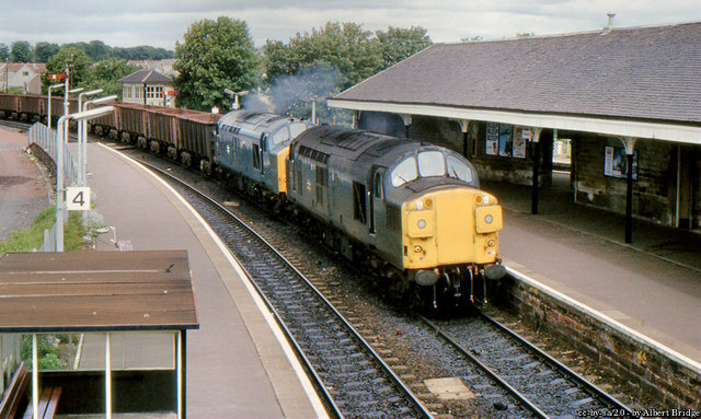 Ore train, Kilwinning, North Ayrshire 1984

37.117 and 37.156 passing Kilwinning with a Ravenscraig - Hunterston train of empty iron-ore wagons.