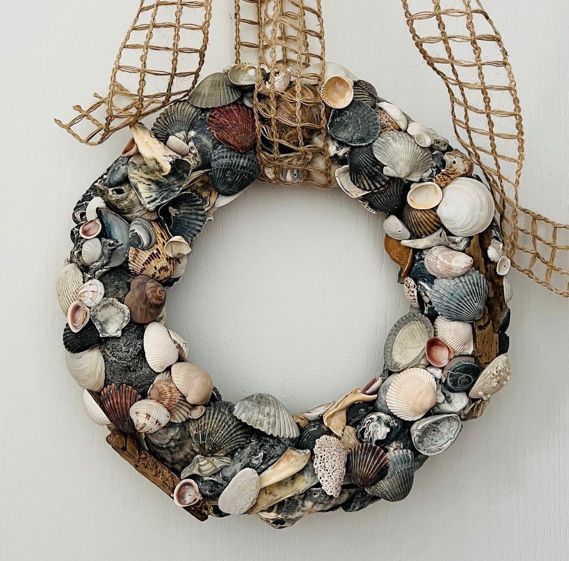 This beautiful coastal seashell wreath is made with shells collected along with Atlantic Coast of Virginia Beach, VA and the Gulf Coast of Clearwater, FL.  They can be used throughout the year to give your home a great coastal vibe. #coastaldecor #coastalliving #coastal