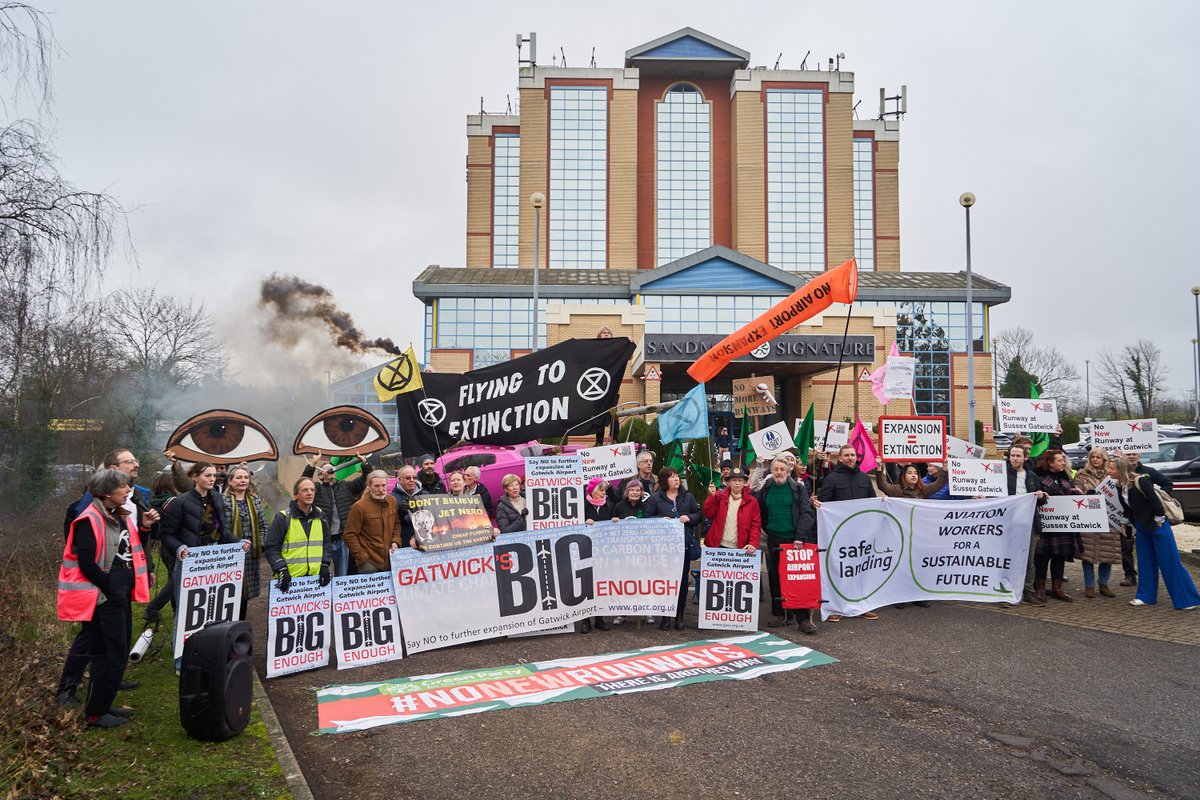 Protesters against the expansion of Gatwick airport at the Sandman Signature London Gatwick Hotel on 28th Feb 2024 Banners are held reading "Gatwick is Big Enough", "No New Runways" and "Flying To Extinction"