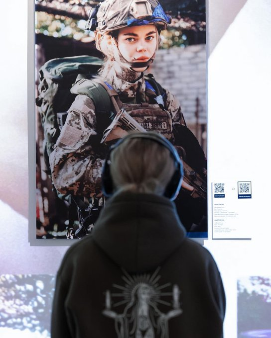 UkraineworldD's tweet photo. Auf diesem Foto blickt Anastasia Mutsey, eine ukrainische #Soldatin, auf ihr eigenes Bild, das in der Ausstellung „Hear the Servicewoman“ gezeigt wird.
Dieses audiovisuelle Projekt soll Licht auf die Herausforderungen werfen, mit denen Frauen im #Militär konfrontiert sind.
📷: Anastasia Mutsey.