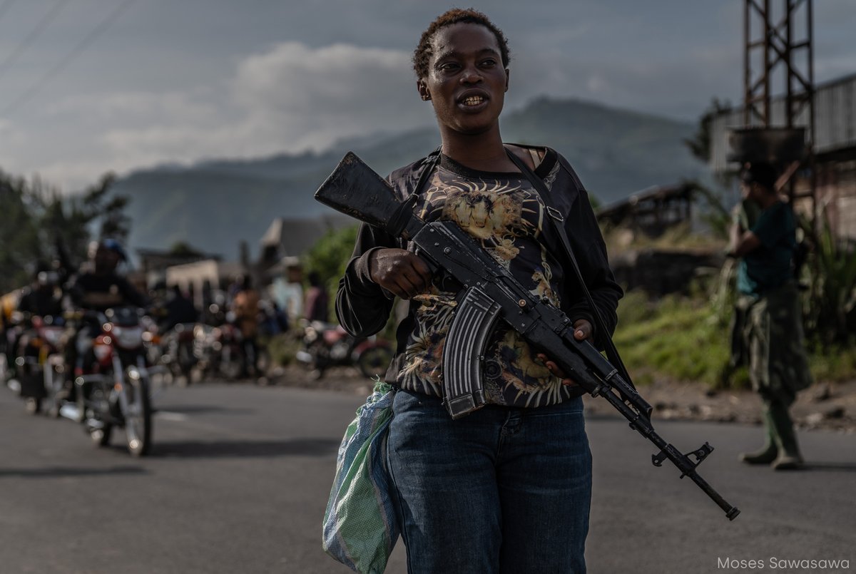 📸 Esta fotografía de @moses_sawasawa muestra a una joven empuñando un arma para defender la ciudad de Sake del asedio de los rebeldes del M23. Este es uno de los lugares donde jóvenes del movimiento Wazalendo se unieron a las Fuerzas Armadas para hacer frente al grupo armado.