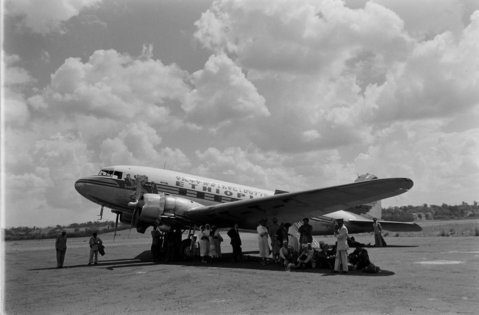 flyethiopian's tweet image. Layover years ago! Passengers sheltering from the blazing sun under the wings of the early bird we used to operate, the Douglas DC-3 back in the days. #throughbackthursday #ethiopianairlines