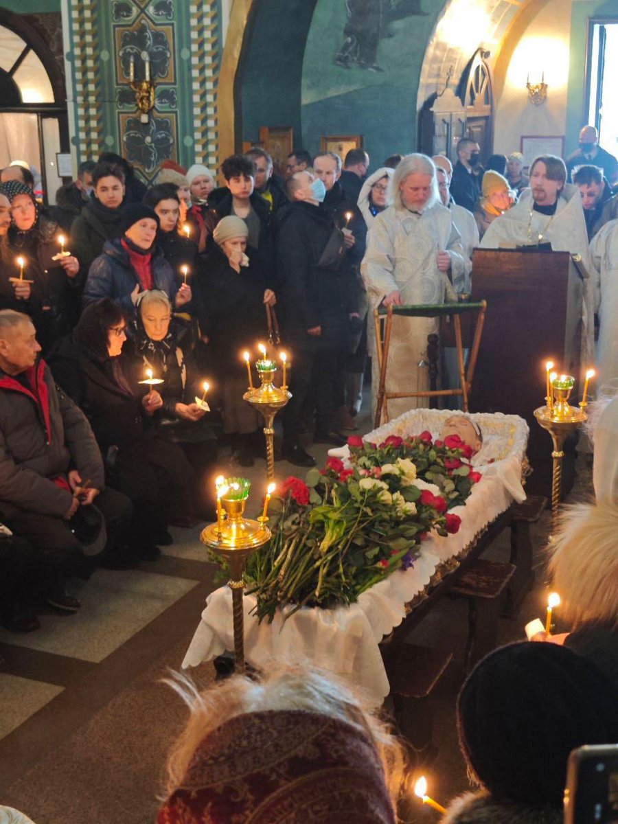 Alexei Navalny lying in state at his memorial service. His parents sit at bottom left.