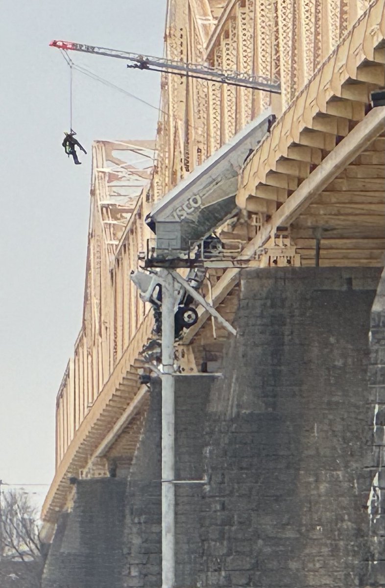 Rescue crews working accident scene where a semi-truck is hanging off the Second Street Bridge.