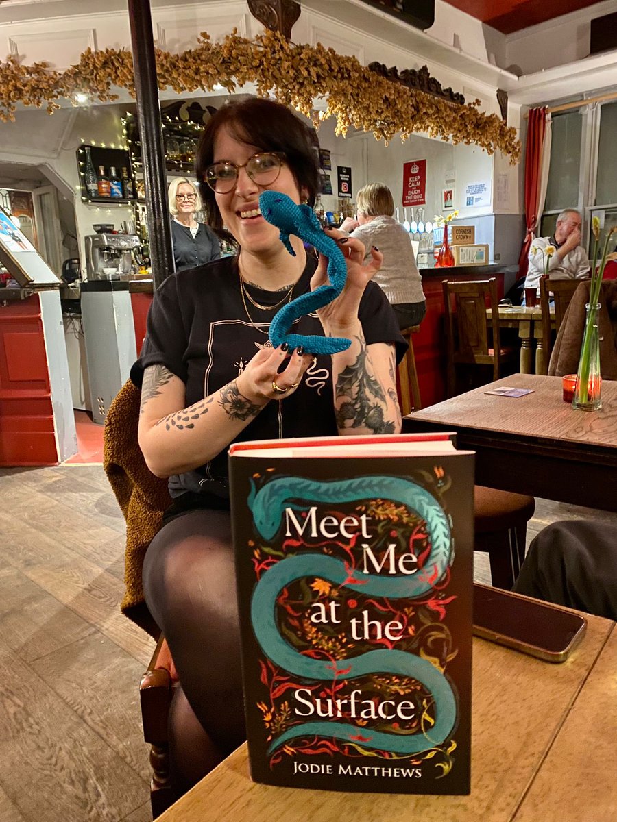 Author on stage // Author in pub with handmade gifted eel 🖤💙 Thank you for having me @Edgybooks !