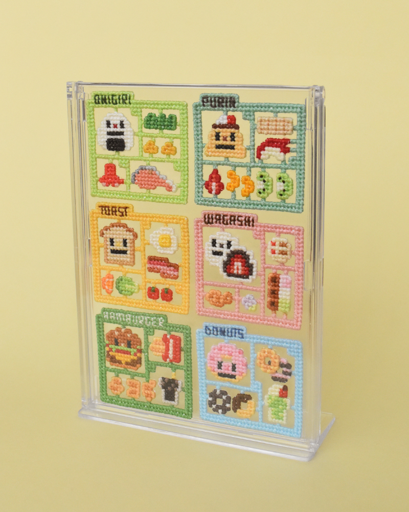 100均のアクスタスタンドというケースが6つぴったりだったので、今までの全部並べました。ケースに厚みがあるので刺繍がつぶれないのがいいです。無意識に甘いのとしょっぱいのを交互に作ってました。 #クロスステッチ #ビニールキャンバス