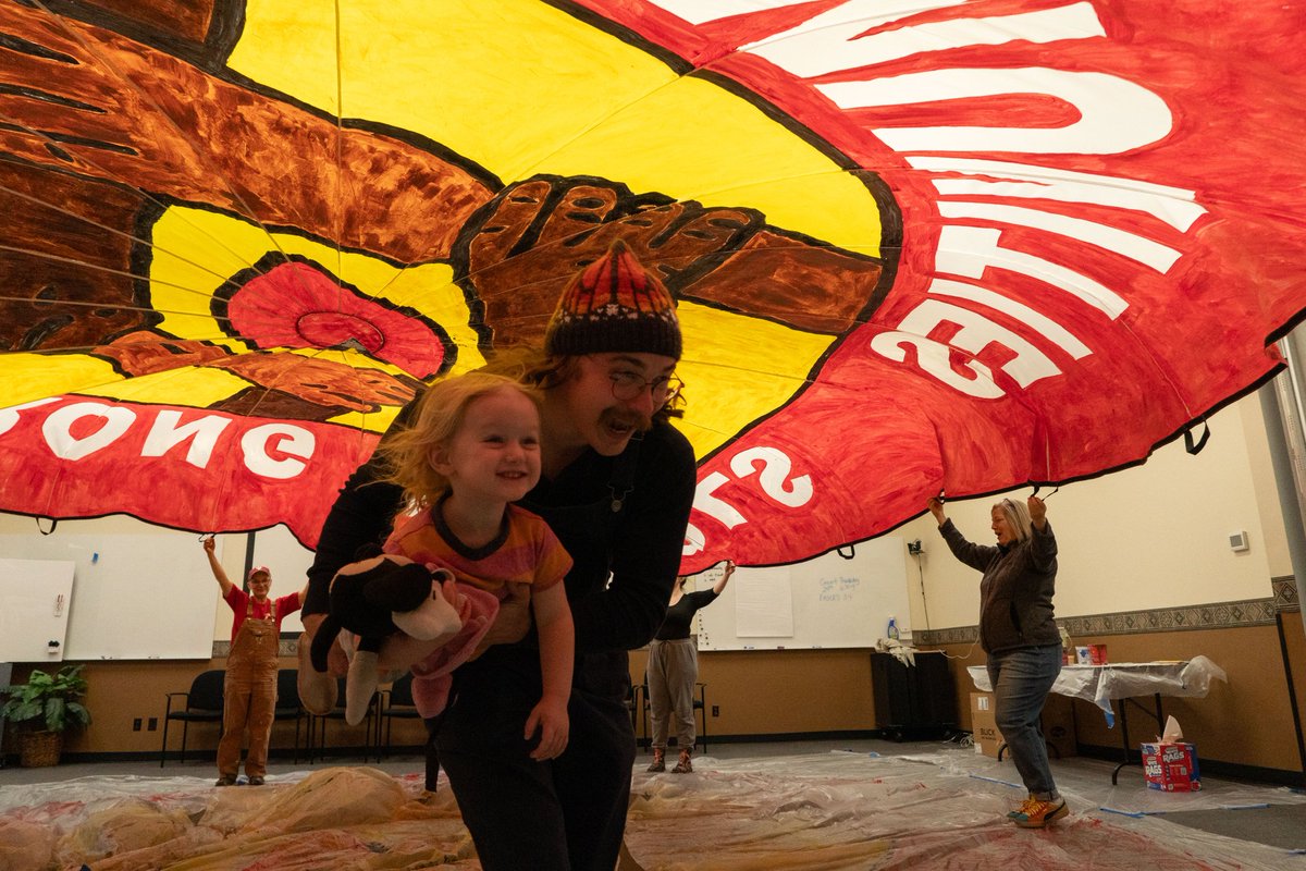 .@SPFE28 After completing the painting of our gigantic 24-foot 'Strong Schools Strong Communities' parachute banner, we took time to have fun running under it to dry it out. St. Paul Federation of Educators will win for their students & communities! #WeAreSPFE #FairContractNow