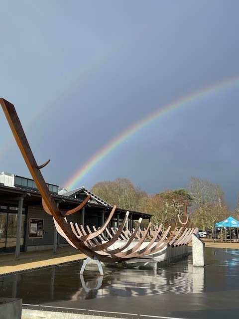 One of the team snapped a photo of this beautiful rainbow over the ship sculpture at #SuttonHoo late last week. You can just make out the second, fainter arc over the top!