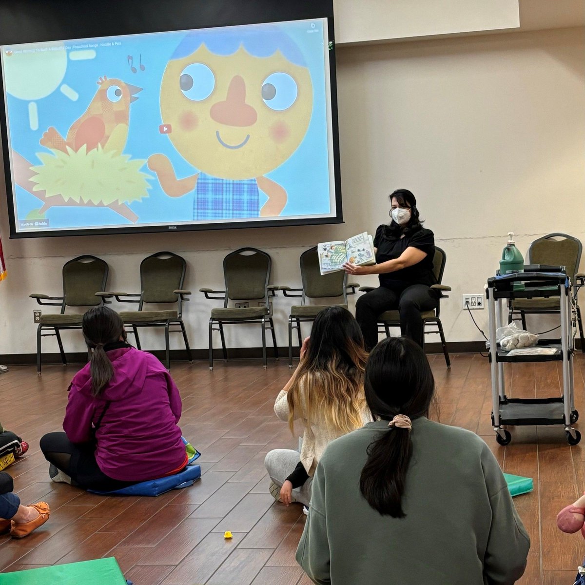 Tomorrow is International Read To Me Day! Here's a picture of Ms. Victoria reading to our amazing preschoolers during our Spring Preschool Program. 🥰