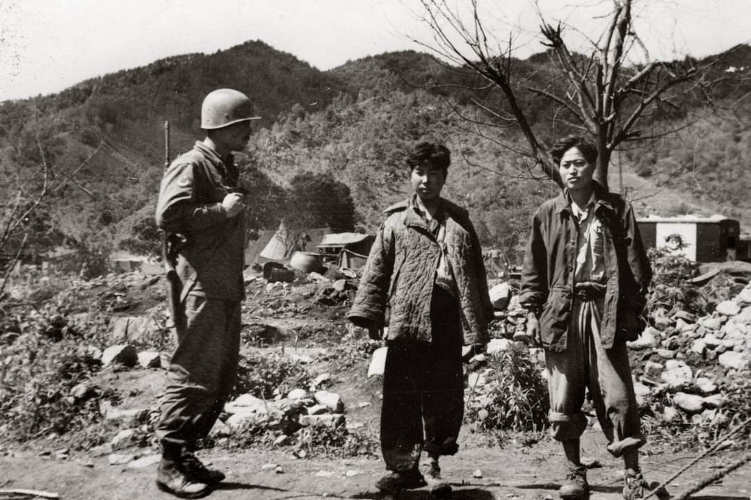 Kore Savaşı sırasında (birliklerimizce) esir alınan Kuzey Koreli askerlerle Türk askeri bir arada.