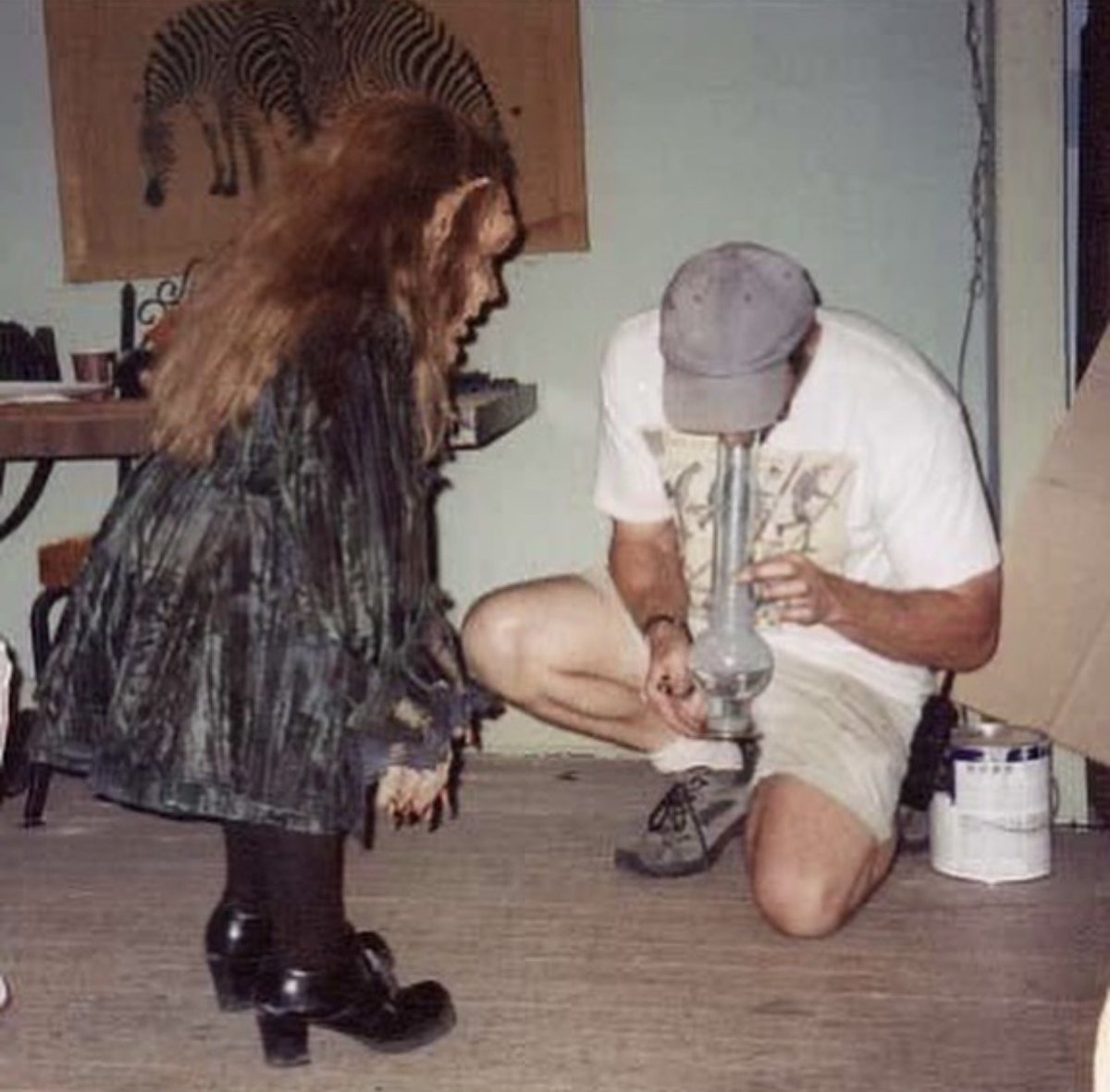 RetroReminiscer's tweet image. A behind the scenes photo of Warwick Davis being taught how to use a bong for LEPRECHAUN IN THE HOOD (2000).
