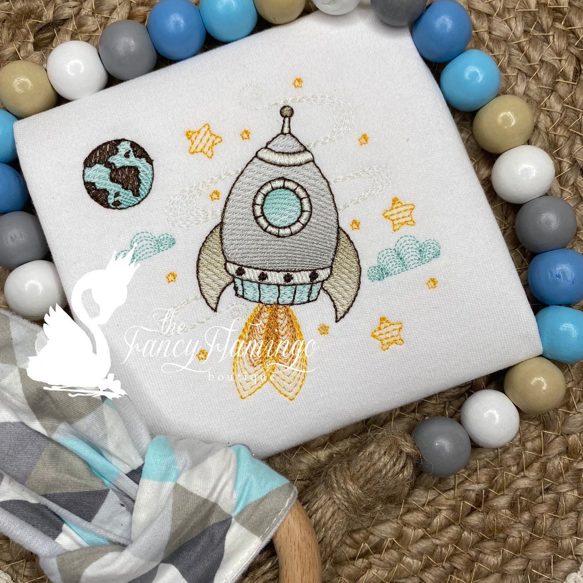 This adorable baby attire features a charming design of a rocket ship soaring through space, surrounded by twinkling stars and a whimsical planet. #rocketship #spaceship #celestialbaby #babyshower #babyfashion #babyshowergiftidea #showergift