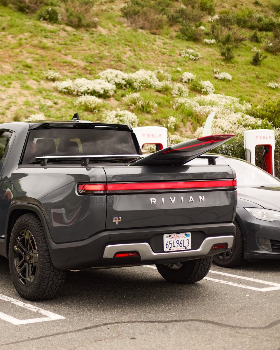 Rivian's tweet image. Fast charger access just doubled. Rivian vehicles can now tap into 15,000+ Tesla Superchargers — rapidly expanding the fast charging experience for our customers. Initially, a NACS DC adapter is needed for access, shipping free to owners starting this spring.…