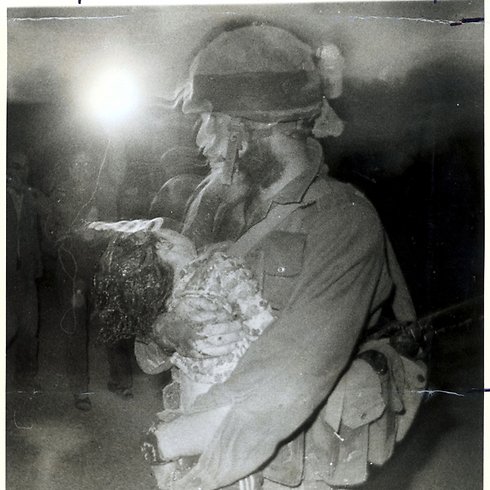 IDF soldier carries the dead body of 4-year-old Einat Haran that was murdered by PFLP terrorist Samir Kuntar by smashing her head multiple times. 1979