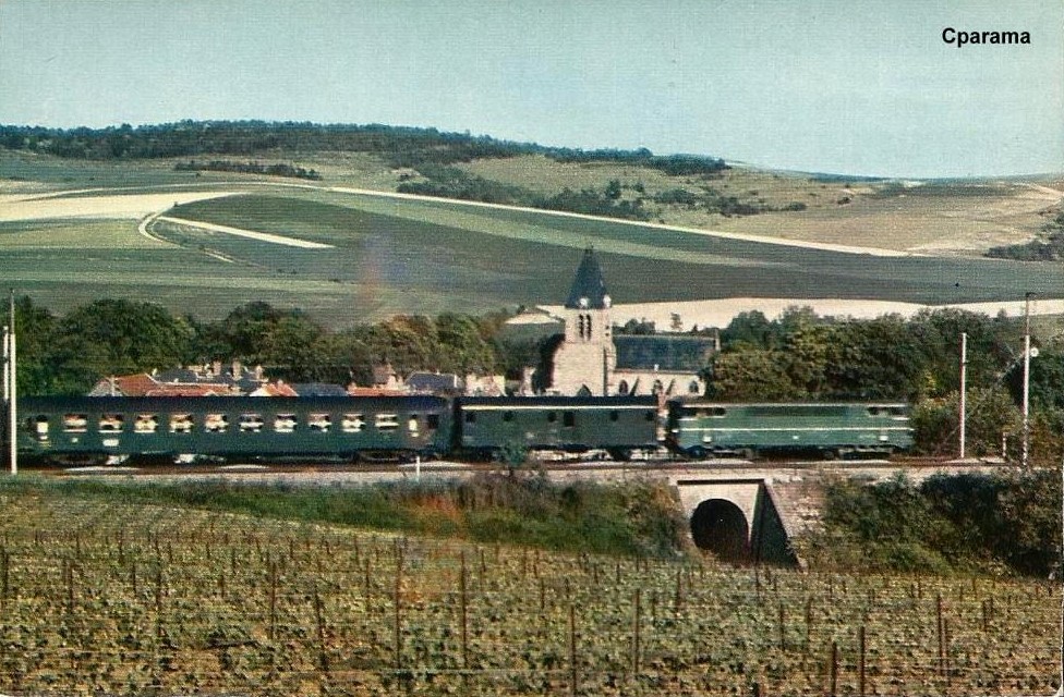 Un Reims - Paris-Est dans les 60's quitte la Montagne de Reims grâce à une =>#BB16000 et traverse le village d'#Avenay (avant Ay et Epernay) au milieu des vignobles. Ligne et livrée permettent à la rame de se fondre dans le paysage.
Auteur inconnu, source: cparama.com