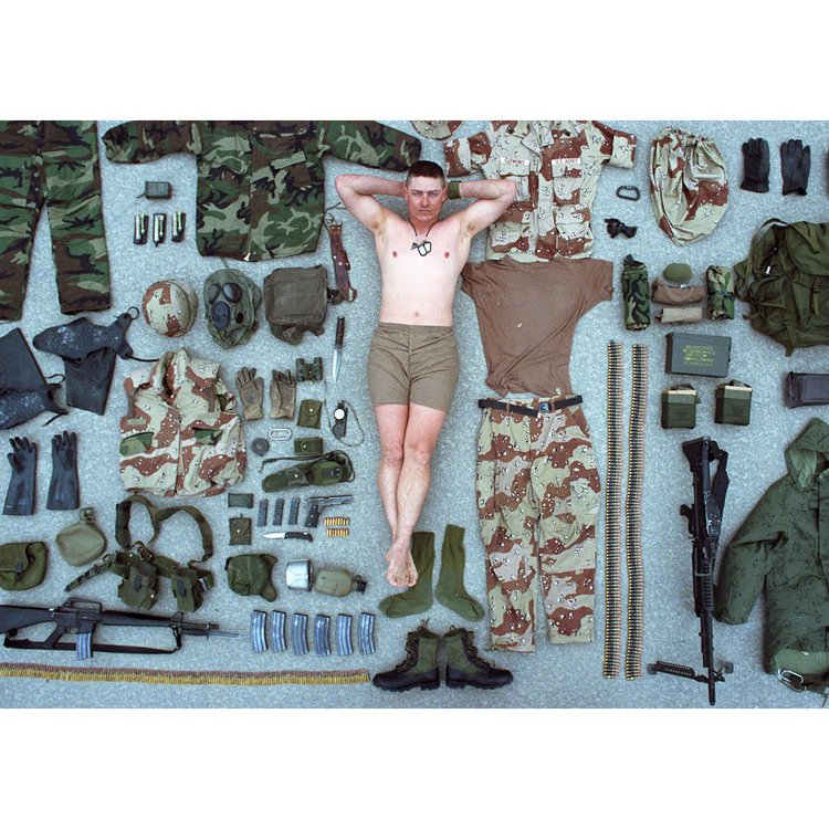 A portrait of US Army Sergeant, Duane Clemons, surrounded by all of his battle gear during a photo shoot. Dhahran, Saudi Arabia. February 24, 1991.