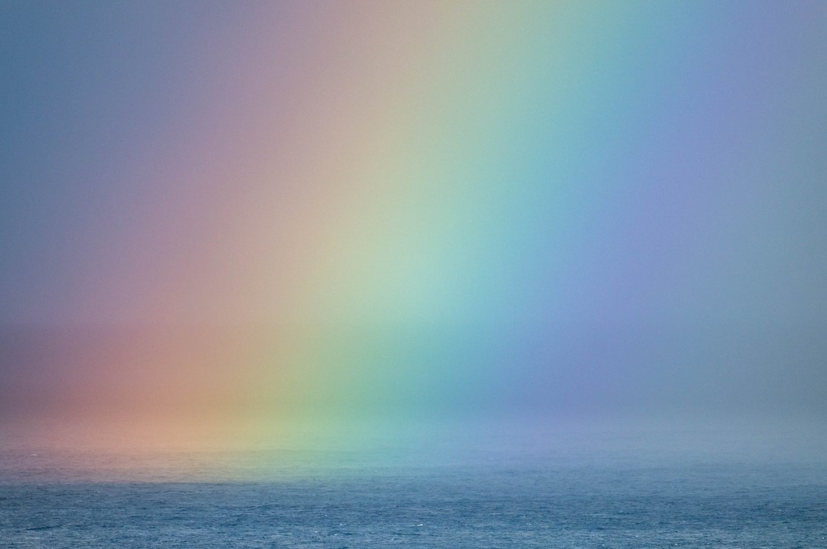 A squall brings alive a rainbow over the Atlantic Ocean.
