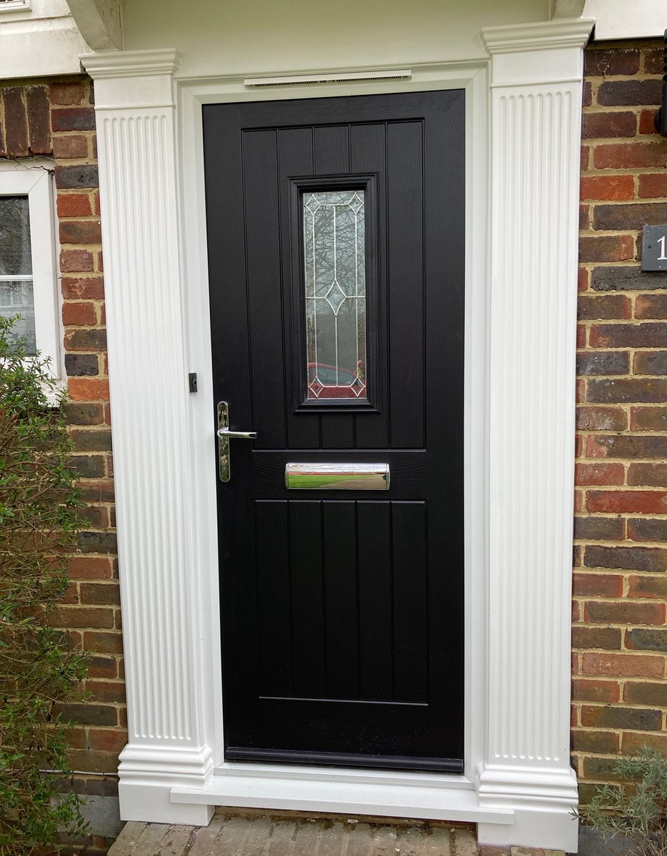 A recently installed Composite Door in Raven Black colour with white moulded GRP Georgian pillars either side.