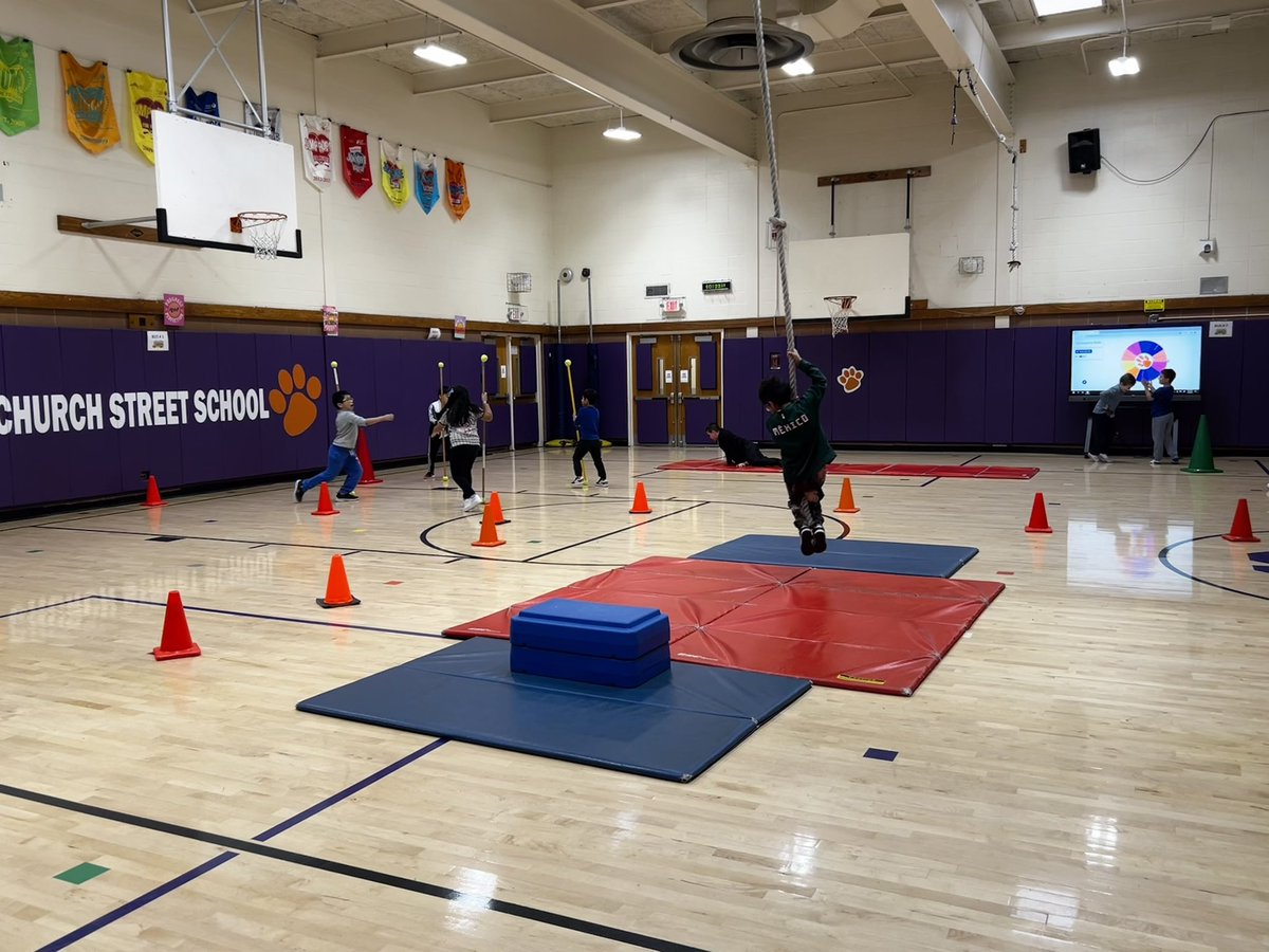 PEwithCoachY's tweet photo. Swinging into the weekend during gymnastics stations with our @ChurchStreet_WP Champions! 
Students practiced rope swing, roller racers, stick exchange and their rolling and animal walk skills. Love incorporating our Ben Q board into the stations #physed #technology #elementarype https://t.co/0FBclqlGek