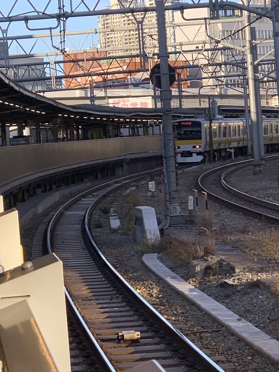 F1week's tweet image. 飯田橋駅ホーム手前で、意味不明に5分ほど？停車していた新宿方面行き総武線。何処かで緊急停車があったのかな？　もう先頭車両はホーム入ってきてずっと止まってる画はなかなかシュールだった。案内もなく何事も無かったように運行再開。