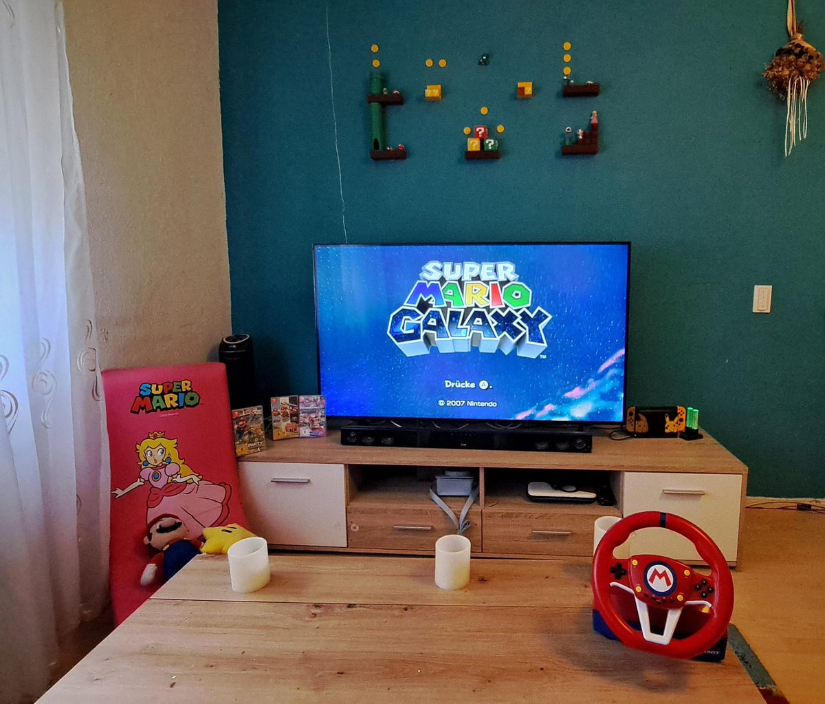 DeathKidSkinner's tweet photo. @NintendoConnect @NintendoDE @CarreraRennbahn Wir haben uns zu Hause ein kleines Mario Paradies für unsere Tochter im Wohnzimmer. Sie liebt Mario über alles. Deswegen hat sie ihren eigenen Peach Gaming Sessel mit Mario Kart Lenkrad und Plüschis. Das Diorama überm TV haben wir selbst 3D gedruckt zum abrunden https://t.co/RHbmFSSxKg