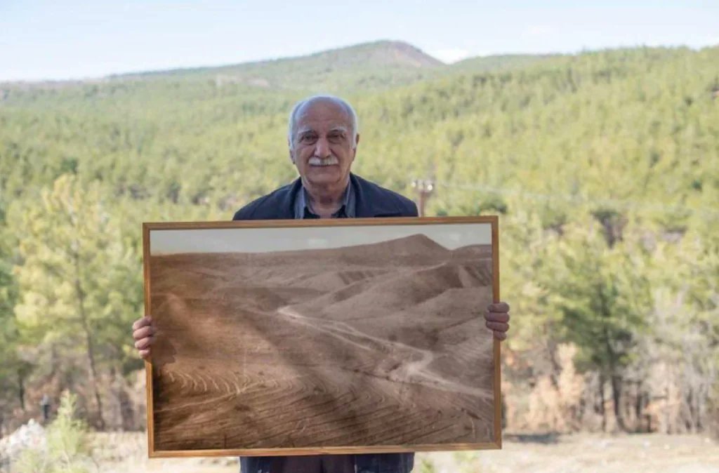 Rainmaker1973's tweet photo. Man posing with picture of the forest he restored.

Sehmus Erginoglu began by clearing out rubbish from his hometown in Turkey 30 years ago and eventually started to plant saplings. Today the site is home to a small forest of around 11,000 trees. https://t.co/MWwiKKsMmB