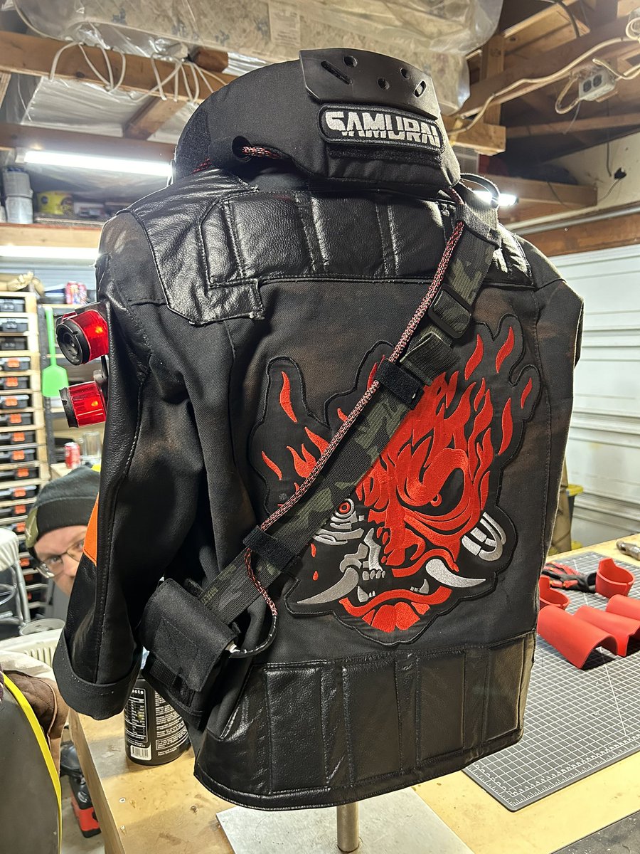 TheRealEvanCray's tweet photo. Some more updates! Cybernetic forearms are painted with their base red. The gloves are repainted to be red. And I think the jacket is done…for now. BUT! It runs under its own power now with a small power bank that I keep on the strap on the jacket. #cyberpunk https://t.co/HETFvNUsIF