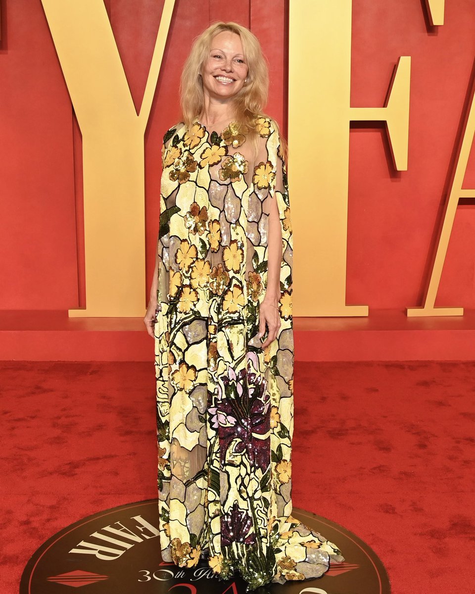 OscardelaRenta's tweet photo. A beaming @pamelaanderson arrives at the #VanityFairOscarParty in the #odlrfall2024 stained glass-inspired caftan. Accounting for over 1,050 hours of embroidery, the gown boasts a multi-chromatic palette of sequins. #odlrredcarpet https://t.co/xRHm1kygGQ