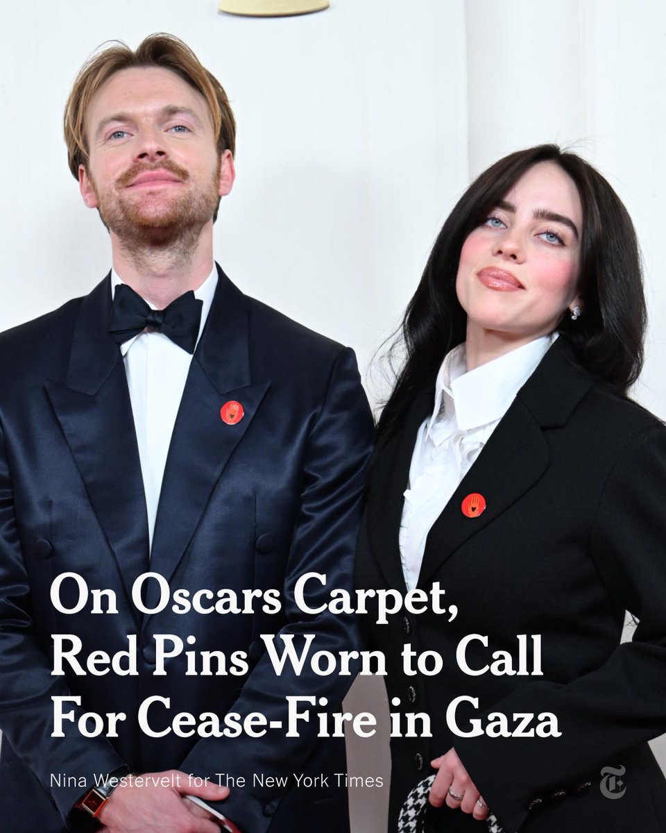 nytimes's tweet photo. Billie Eilish, Finneas and Ramy Youssef were among the Oscars attendees who wore red pins calling for a cease-fire in Gaza. The pins also represent a call for increased humanitarian aid and the release of all hostages, the Artists4Ceasefire group said. https://t.co/fk2Kj1fqER https://t.co/MkoApMzAoc