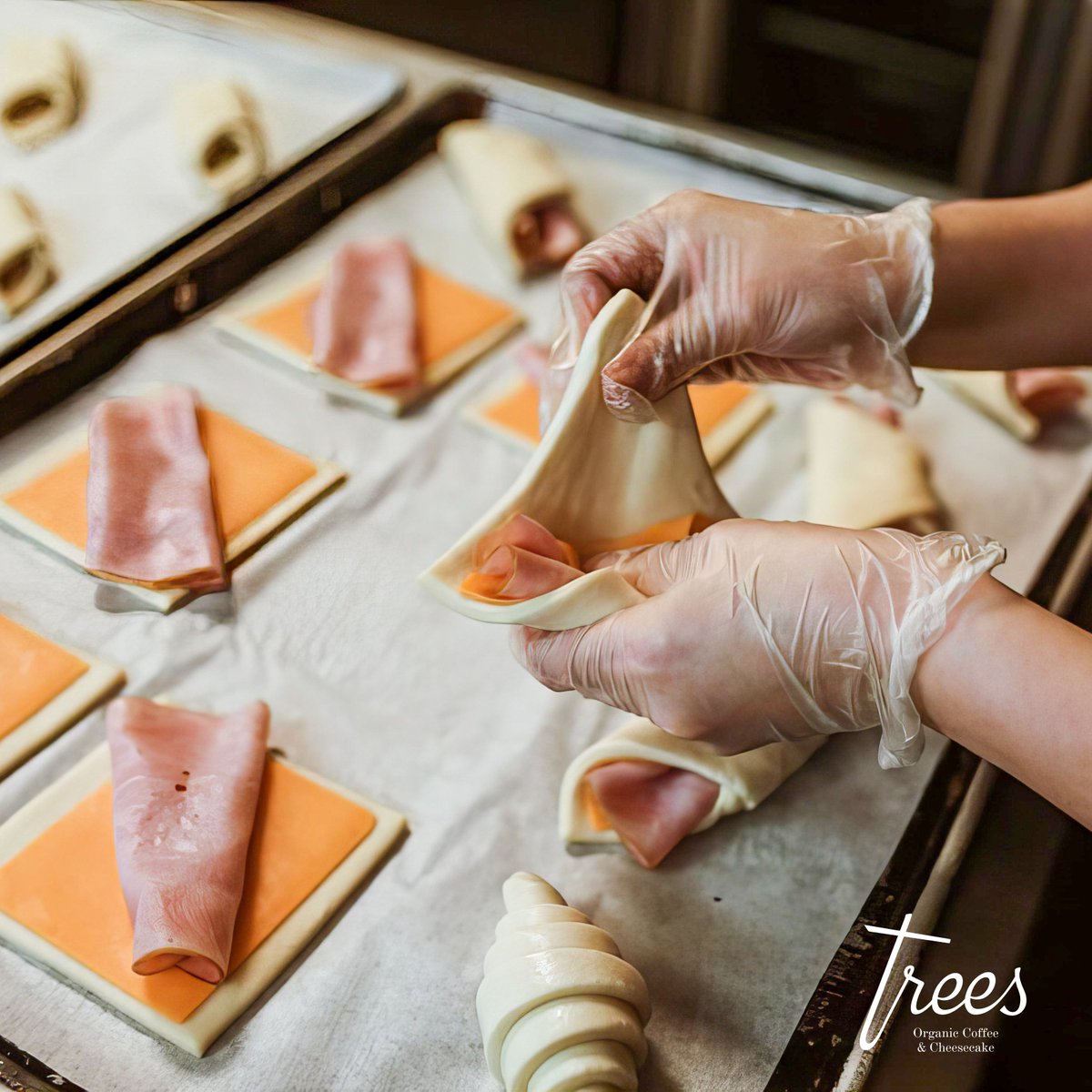In the warmth of our kitchen, skilled hands artfully roll fresh and delicious croissants. Each pastry perfectly blends delicate puff pastry, rich cheese, and thinly sliced ham. We promise you a bite of comfort and quality. Come taste the craft at Trees! 🤩