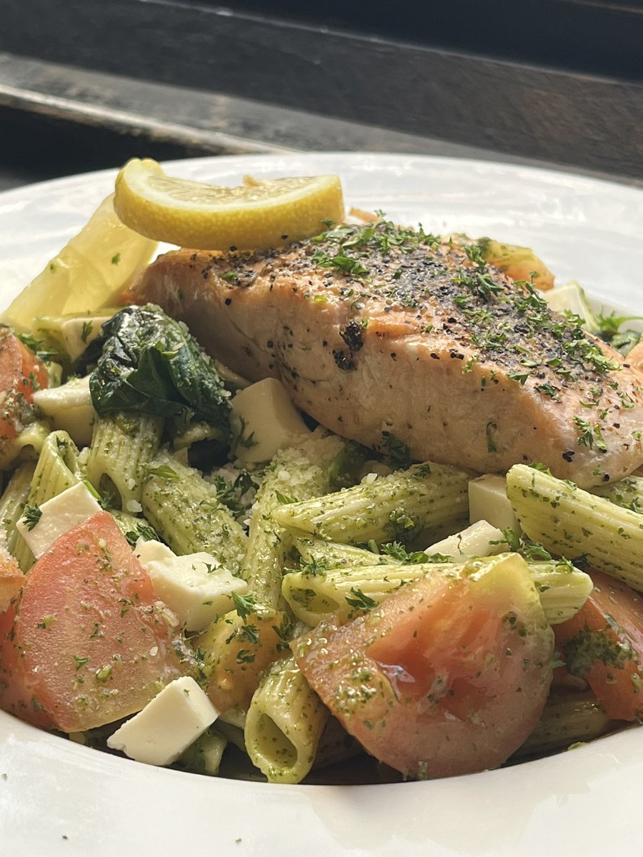 Grilled salmon over pesto penne with tomatoes and mozzarella