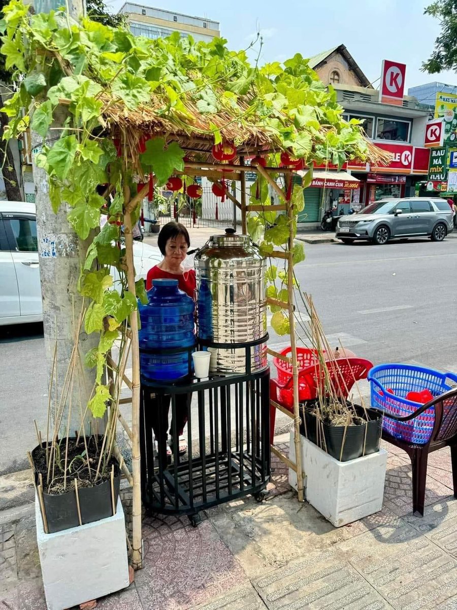 CelricTran's tweet photo. SÀI GÒN TỬ TẾ 
Một giờ trưa trời nắng nóng như đổ lửa, một bạn shipper tấp xe vào quán nước “Không Đồng” trước nhà thờ Mạc Ty Nho, bạn lấy ra chai nhựa rồi tự mở vòi hứng nước từ bình, bạn uống một hơi rồi lại hứng nước tiếp cho đầy và lên xe đi tiếp.

Hai bình nước một mát một lạnh trước nhà thờ Mạc Ty Nho rất độc đáo nó đặt dưới một mái lá nhỏ có hai chậu trồng nhiều dây bí thả bò phủ lên mái trông thật mát mắt làm dịu hẳn cái nóng chói chang.

Hai rổ lớn một đựng ly sạch một để ly xài rồi. Trong ly nước miễn phí còn có cả tấm lòng và sự tử tế của người Sài Gòn❤️

#saigon