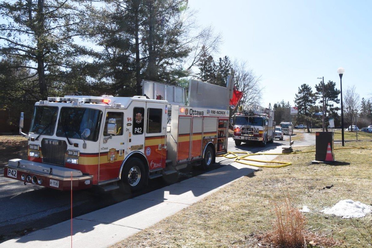 OttFire's tweet photo. Firefighters contained an apartment fire to the unit of origin yesterday in Kanata.
 
At approx. 12:02, we received a call from a monitoring company reporting active fire alarms at a two storey multi-unit residential complex in the 200 block of Penfield Dr. Firefighters arrived on scene 2min after being dispatched to the call and were met with contractors who flagged them to the back of the structure where black smoke was coming from the window and the door of one of the ground floor units where they were working. Firefighters began a fast attack and advanced a hose line to the unit. It was confirmed there were no occupants inside the unit. The fire was located on the wall near the door and the window and was quickly extinguished and brought under control at 12:08, 4min after arriving on scene and before it could spread. Firefighters pulled the soffit on the exterior of the unit to check for any fire extension and none was found. The smoke had migrated through the first floor hallway so Firefighters began ventilation operations using high pressurized fans to remove it out of the structure. Once the smoke was removed, Firefighters checked the units one by one to make sure there was no smoke inside any of them. Three units on the first floor close to the fire unit were found with smoke inside them and it was removed. Multiple units above the fire unit also had smoke inside them and it was also removed by fire crews. The air quality was monitored and was confirmed to be safe before allowing all the residents to return to their units at 13:42. At 13:44, a "firewatch" was set up to have a pump remain on scene to monitor for any flare ups. There are no reported injuries. #OttNews 

📸 OFS Photographer Jean Lalonde