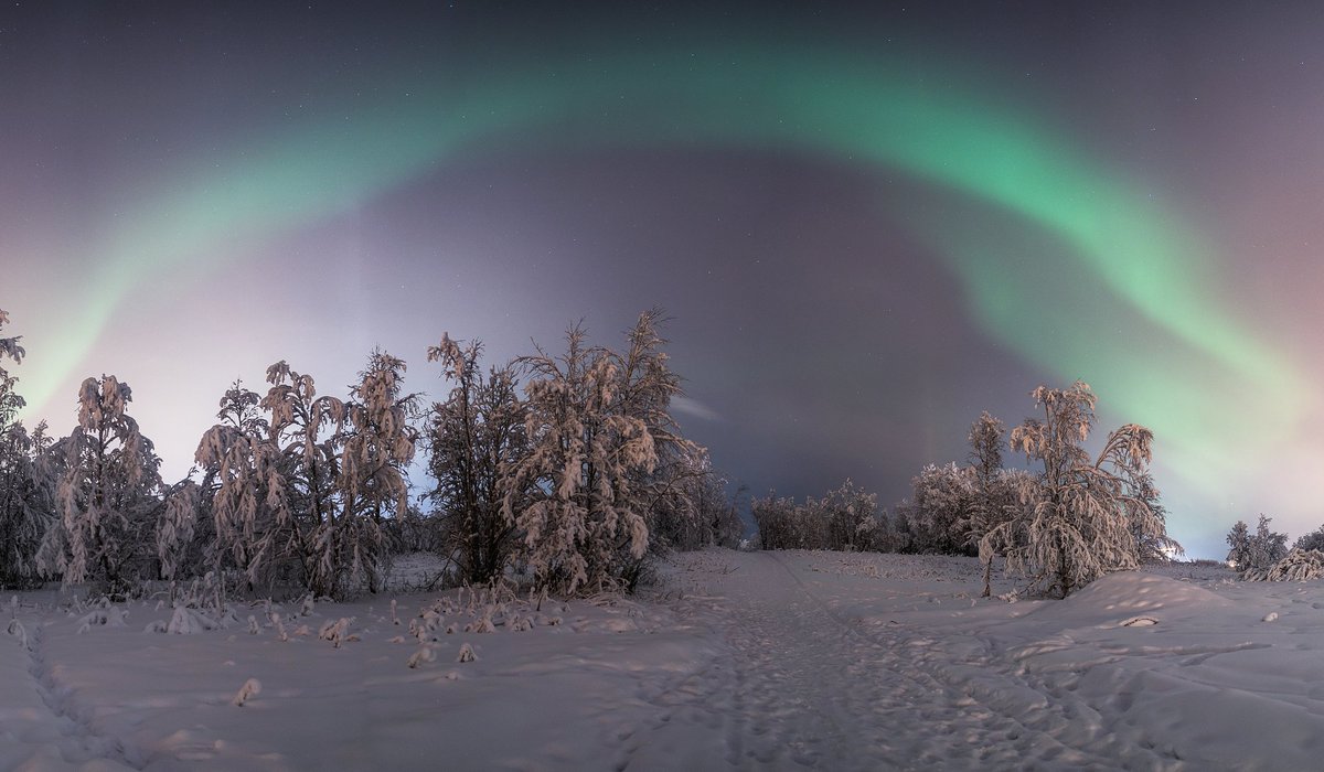 One winter night in Kiruna. 
Walking a frozen trail under the arch of aurora.