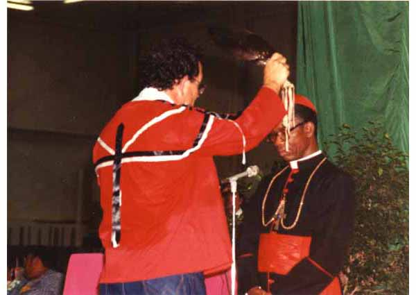 c54587's tweet photo. Shaman shenanigans continued...

Cardinal Arinze ‘blessed’ by an Indian shaman

'Card'. Francis Arinze, then President of the Pontifical Council for Inter-religious Dialogue, participated in an event at the Tekakwitha Conference in Fargo, North Dakota, in 1989. 
On that occasion he celebrated a Mass. Before the Mass, he received a pagan ritual "blessing" from a shaman, who passed an eagle feather over his head invoking the protection of the Manitous (spirits that inhabited nature).