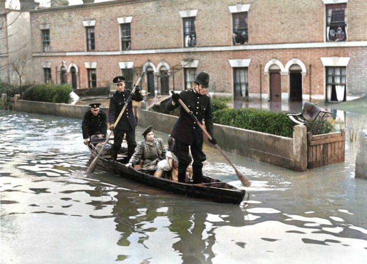 On This Day 13th March 1947: Policemen in a rowing boat rescue inhabitants of Spring Lane, Clapton, London, where flood waters have reached alarming heights after the River Lea burst its banks.