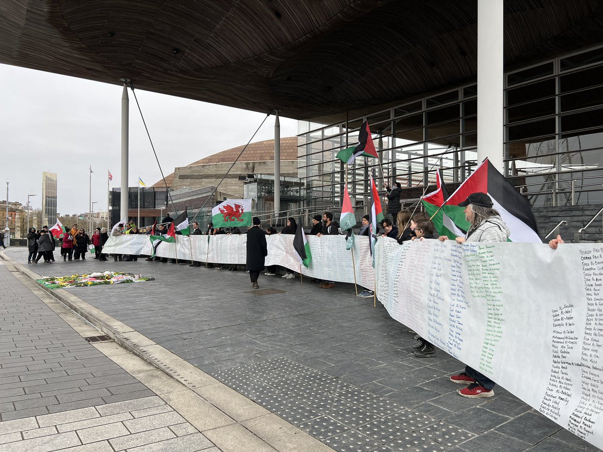 100 people are gathered outside the senedd and have unveiled a banner to remember those who have died in gaza. It is a solem atmosphere. #Palestine #Gaza #Cardiff <a href="/Journo_USW/">Journalism_USW</a>