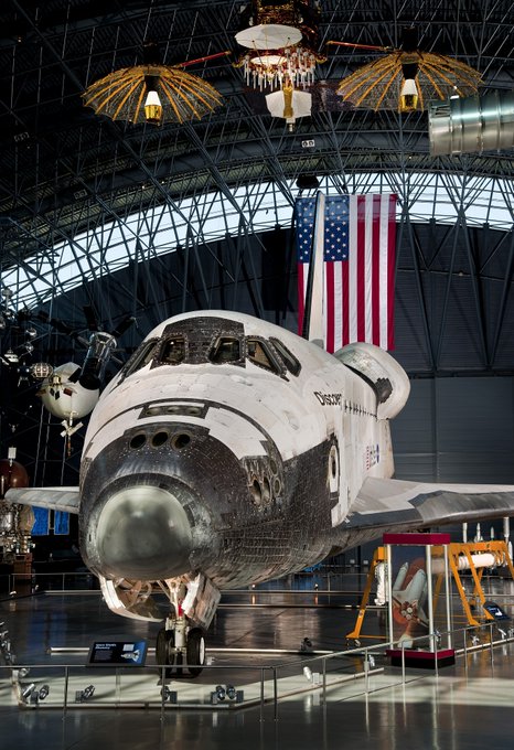 Satellite with two umbrella-shaped antennas above Space Shuttle Discovery 
