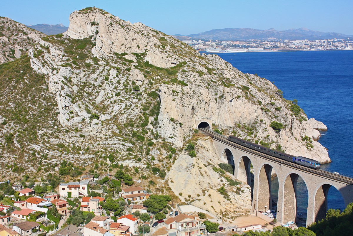 CheminsdeFerTC's tweet photo. Il n'y a pas que des AGC sur la =>#CôteBleue mais aussi des #RRR confiées à des =>#BB67000 (ou =>#BB67400), ici sur le #viaducdelaVesse en 08-09, sortant du #tunneldelaVesse pour entrer dans celui de Niolon. Au fond, Marseille !
Auteur : Wayland Smith par https://t.co/wfICWM5NxE https://t.co/UacUnpdOKy