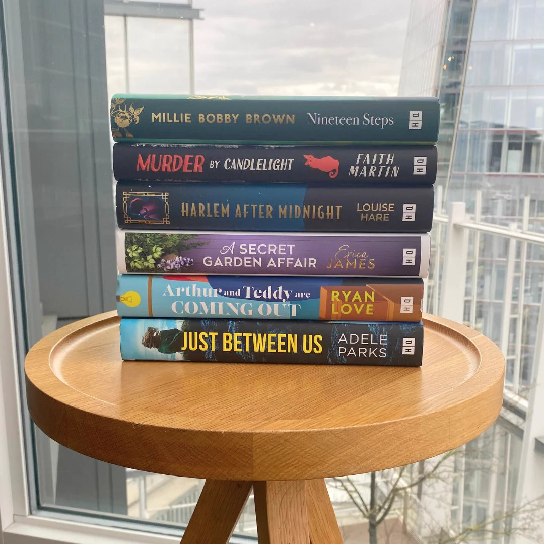 Just Between Us, Arthur and Teddy are Coming Out, A Secret Garden Affair, Harlem After Midnight, Murder by Candlelight, and Nineteen Steps on a table.