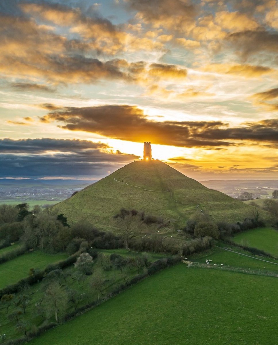 We're beginning the weekend with this beautiful image captured recently of Glastonbury Tor illuminated by the setting sun ✨ 📸 @Glastomichelle #GlastonburyTor #VisitSomerset