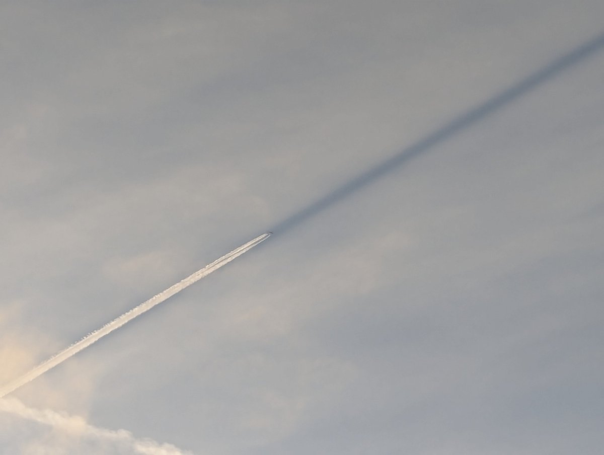 Joranium's tweet photo. Neat - this plane was flying so directly away from the sun that it was flying into the shadow cast by its own trail. https://t.co/w7RlmCsCXm