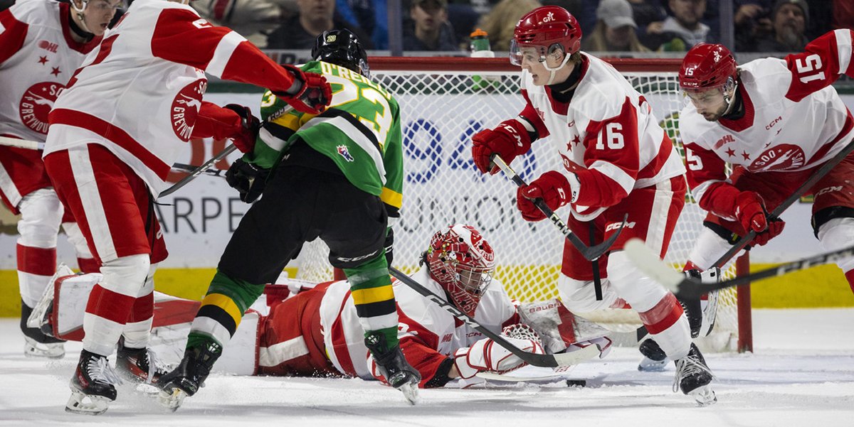 Sam O’Reilly of the @LondonKnights attracts the attention of virtually the entire @SooGreyhounds team as he fights for a loose puck as he’s checked by Christopher Brown in front of Charlie Schenkel with Spencer Evans and Jacob Frasca of the Soo Greyhounds moving in @BudGardens